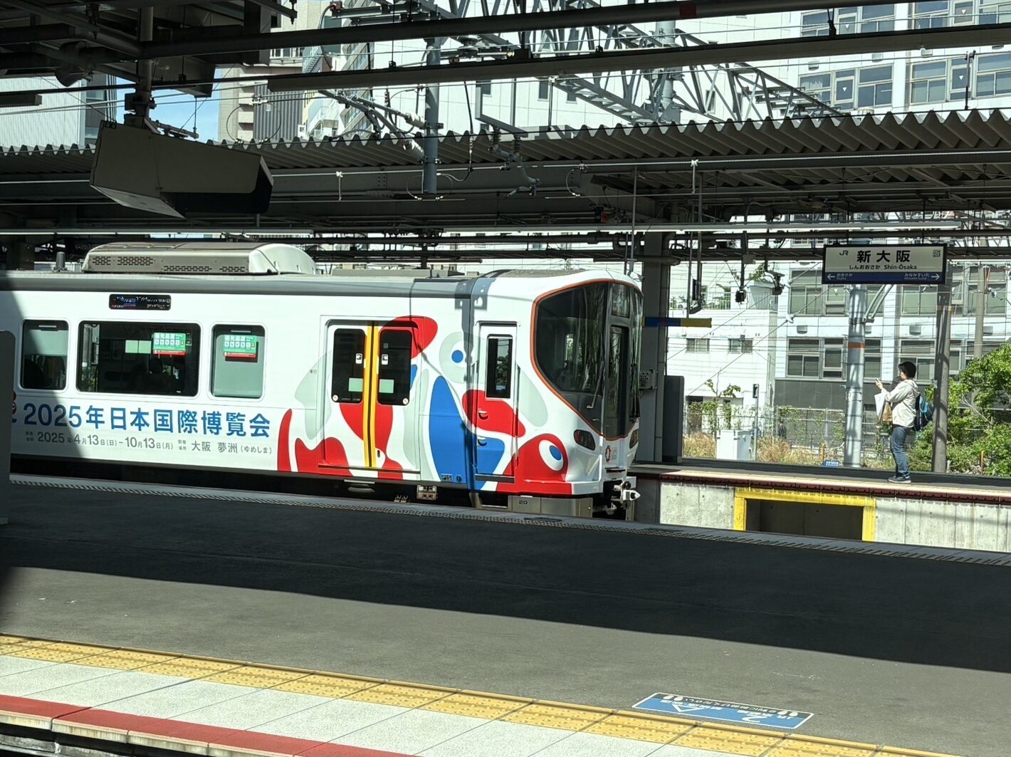 新大阪に停車の大阪万博のラッピング電車で大阪万博のイメージ目的